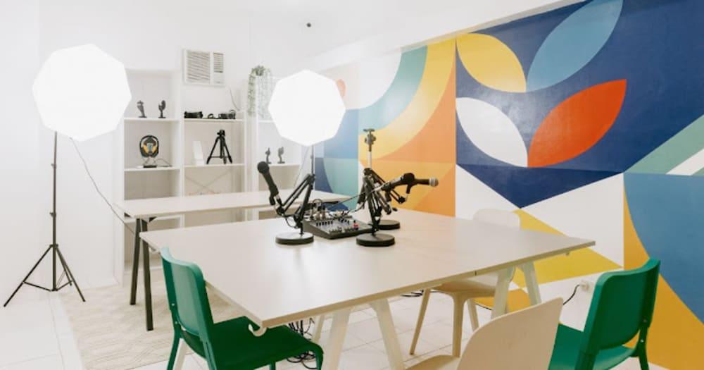 Young content creators using cameras, tablets, and editing computers inside a modern creative studio and co-working space