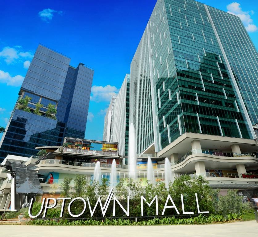 Tourists shopping and exploring modern interiors inside Uptown Mall in Bonifacio Global City
