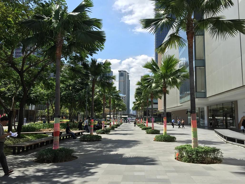 Tourists walking along open-air streets, outdoor cafés, parks, and skyline lifestyle spaces around Bonifacio Global City