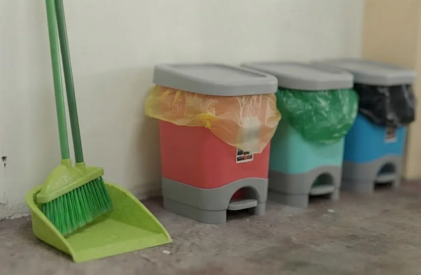 Segregated trash bins and cleaning materials.