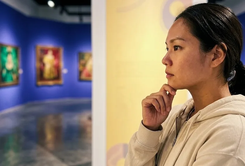 A young woman intently pondering on the museum display..